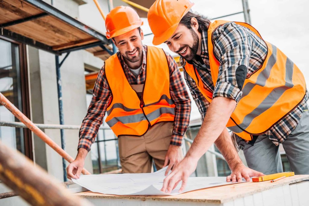 Steel Shop Detailing Best Practices in 2025 4 handsome smiling builders looking at construction plan